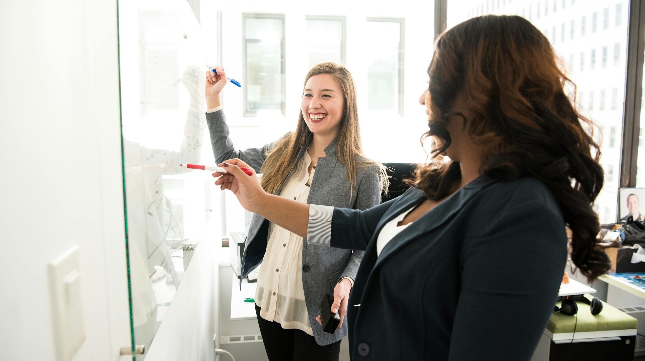 Two Women in Front of Dry-erase Board